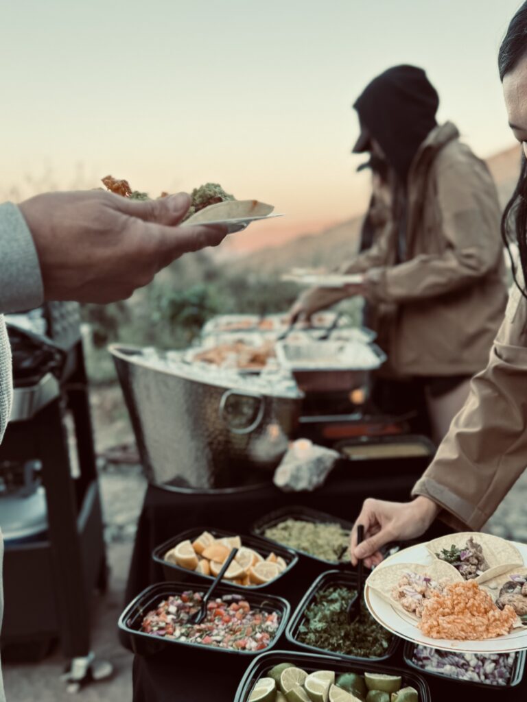 A chef preparing an outdoor meal for a camp buyout
